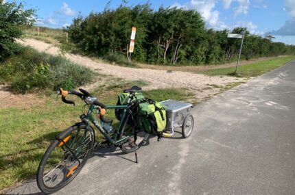 Fahrrad mit Anhänger und Gepäck am Wegrand